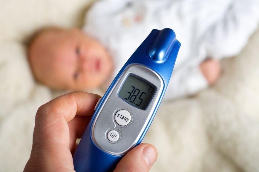 digitales Fieberthermometer, Baby verschwommen im Hintergrund