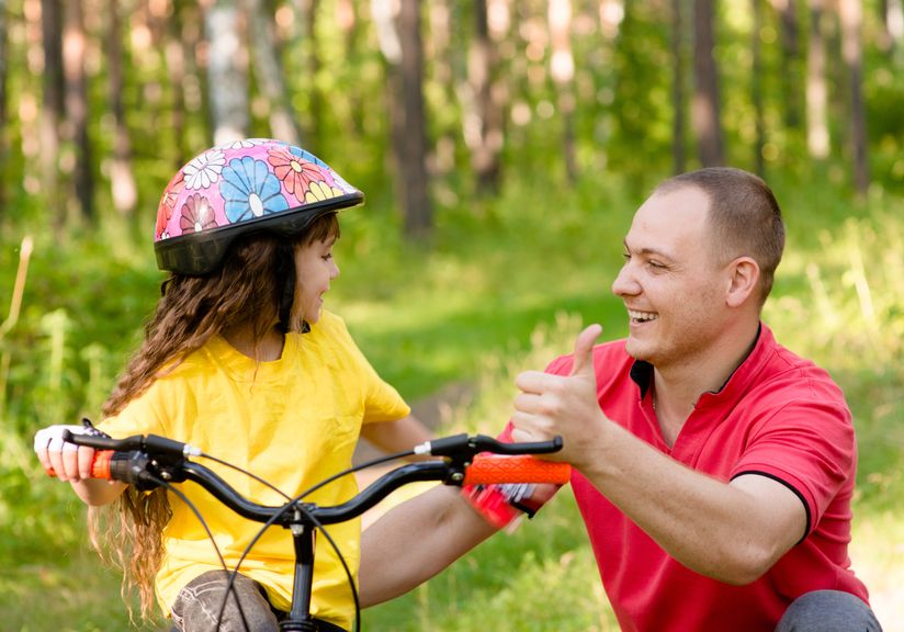 Vater hilft Tochter beim Fahrradfahren