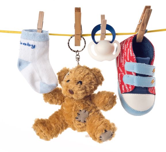 Teddbär mit Socken und Babyschuh aufgehängt
