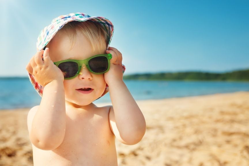 Baby mit Sonnenbrille und Sonnenhut