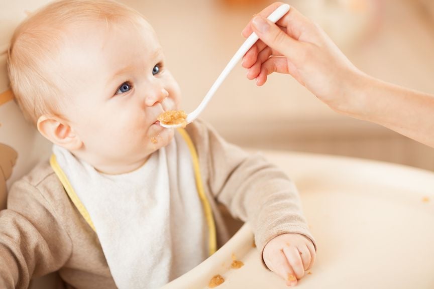 Baby wird mit Brei gefüttert