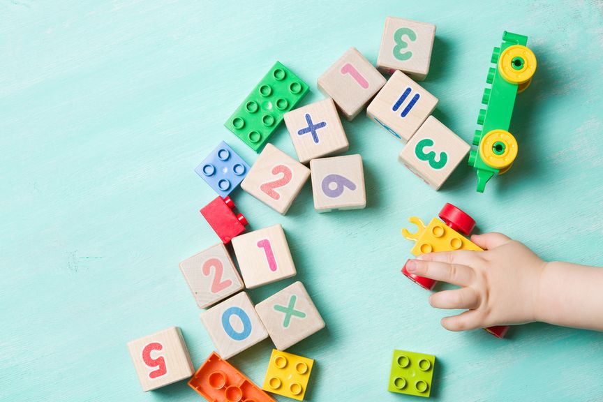 linke Babyhand greift nach einem Spielzeug