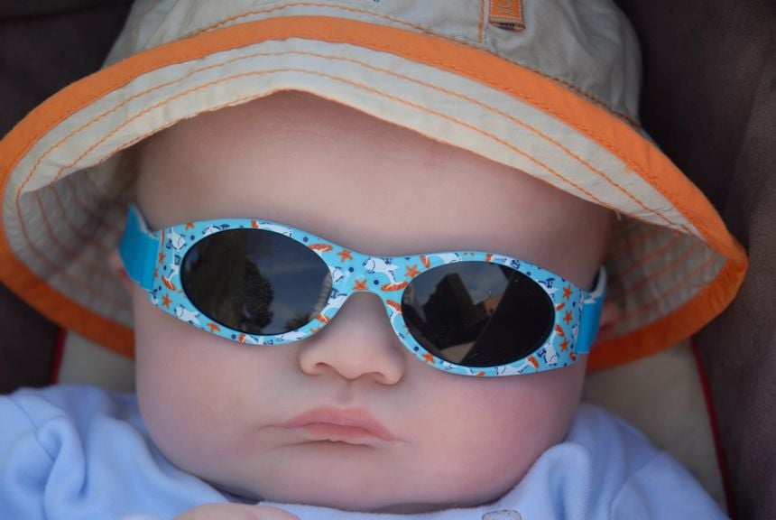 Babygesicht mit Sonnenhut und Sonnenbrille