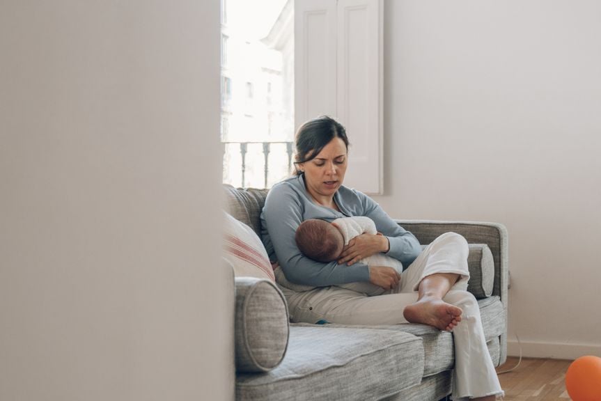 Mutter stillt ihr Baby auf dem Sofa