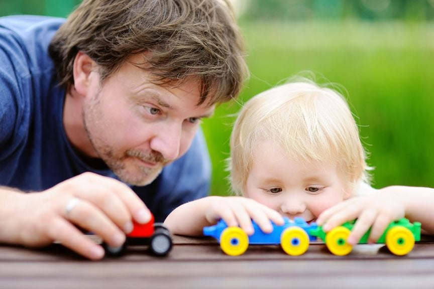 Vater spielt mit Kind auf dem Gartentisch