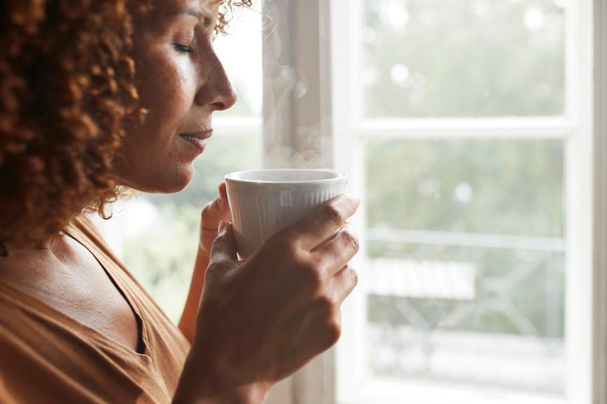 Frau bläst in eine Tasse