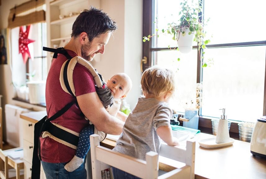 Vater mit Baby und Kind zu Hause beim Abwasch