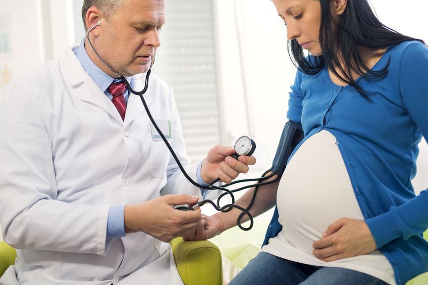 Arzt misst den Blutdruck bei einer Schwangeren