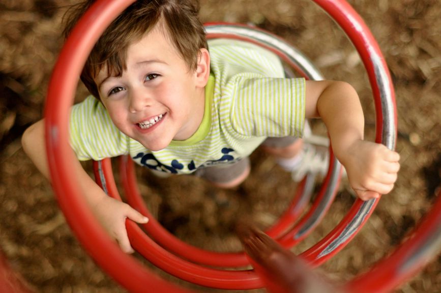 Kind klettert auf dem Spielplatz