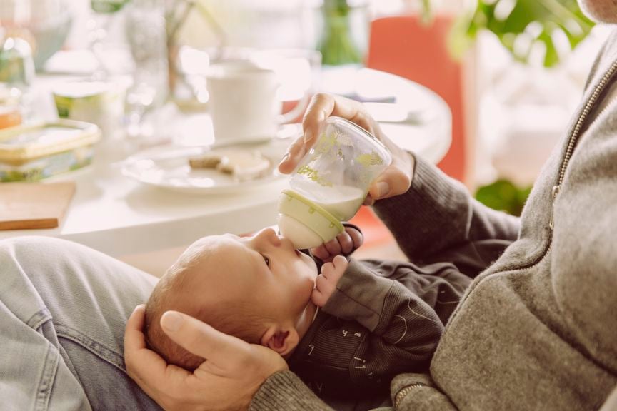 Vater füttert Baby mit Schoppen