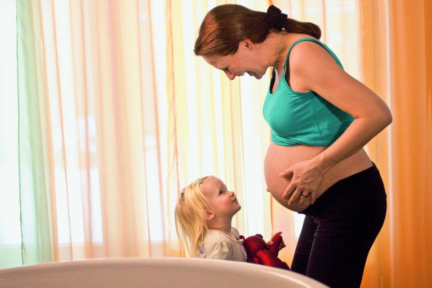 Schwangere Frau mit Kleinkind im Gebärzimmer