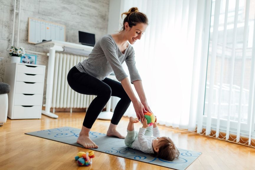 Mutter macht Sport, Baby liegt dabei auf dem Boden