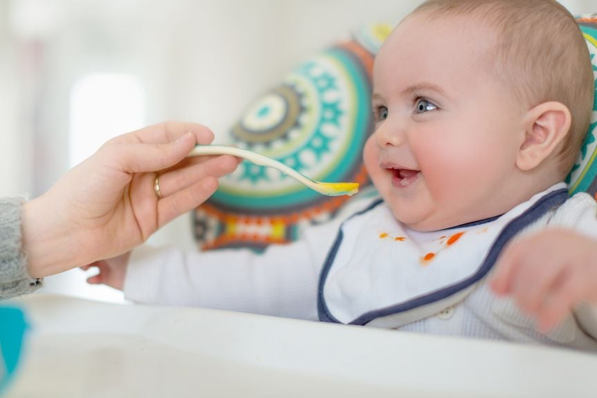 Baby wird mit Brei gefüttert