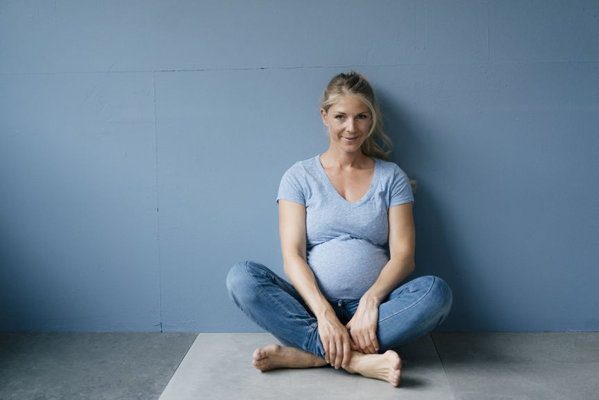 Schwangere im Schneidersitz am Boden