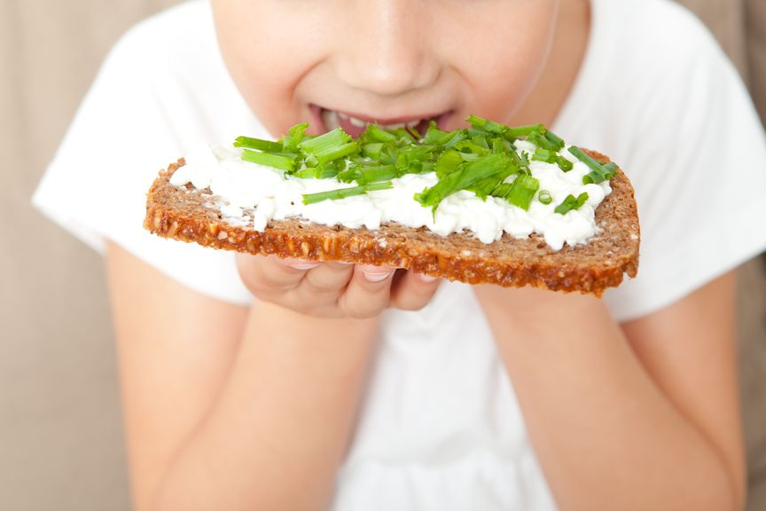 Kind beisst in eine Brotscheibe