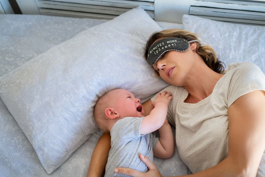 Mutter mit schreiendem Baby im Bett