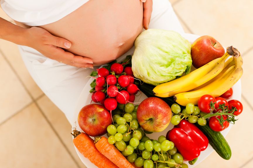 Schwangere mit frischem Gemüse und Früchten