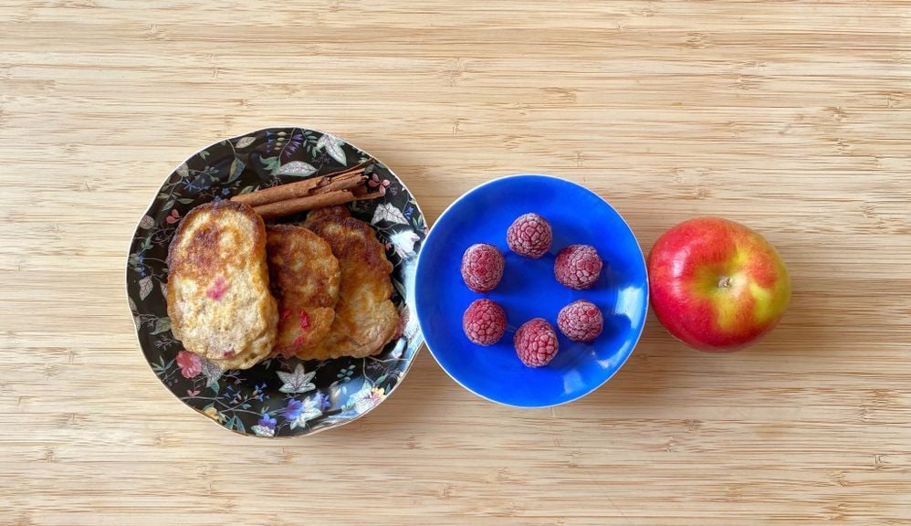 Apfel-Himbeer-Küchlein mit gefrorenen Himbeeren und einem Apfel