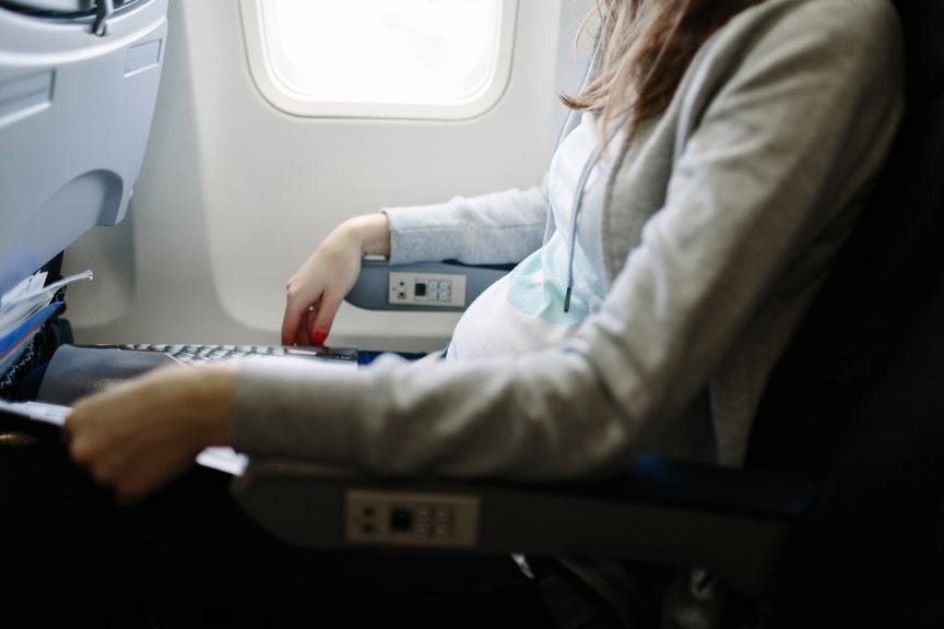 Schwangere sitzt im Flugzeug