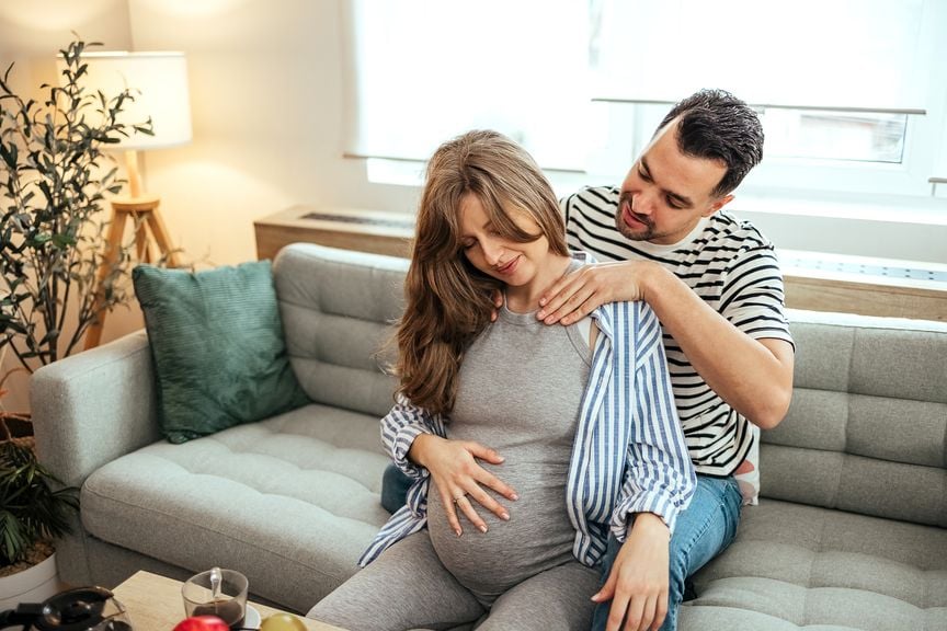 Partner massiert den Hals der Schwangeren