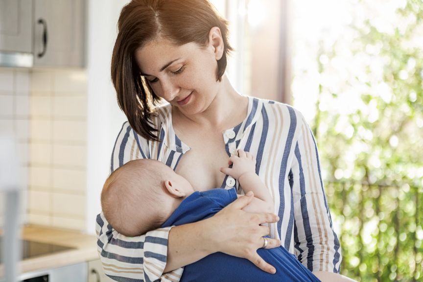 Mutter hält und stillt ihr Baby