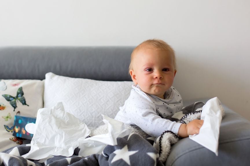 Baby mit Nastüchern auf dem Sofa