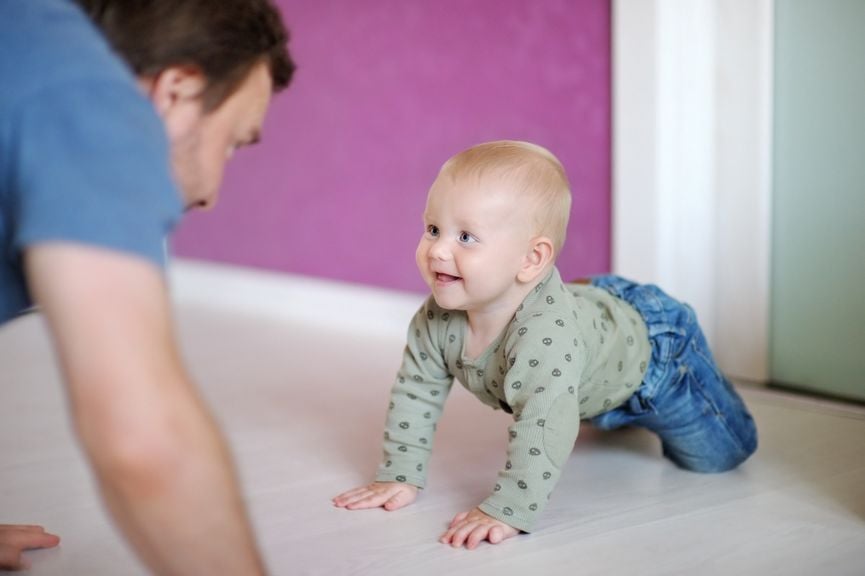 Vater und Baby krabbeln aufeinander zu