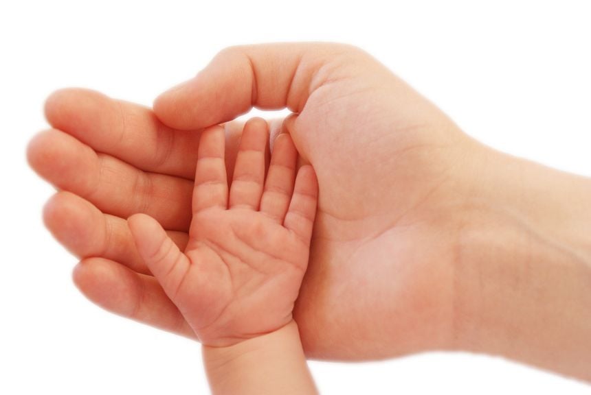 Babys Hand gegen Vaters Hand
