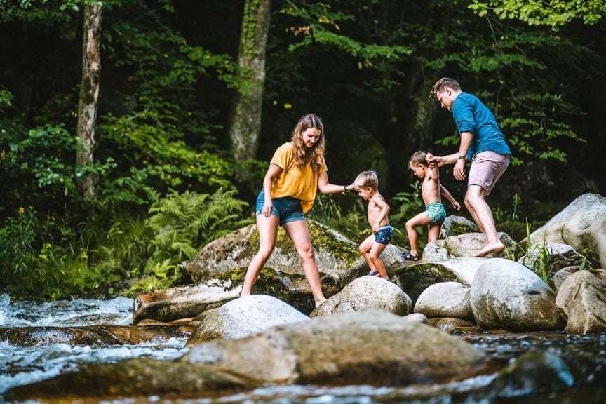 Familie mit zwei kleinen Jungen am Bach