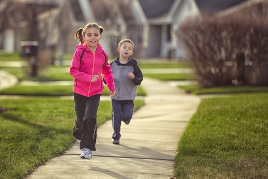 Junge und Mädchen joggen auf dem Trottoir