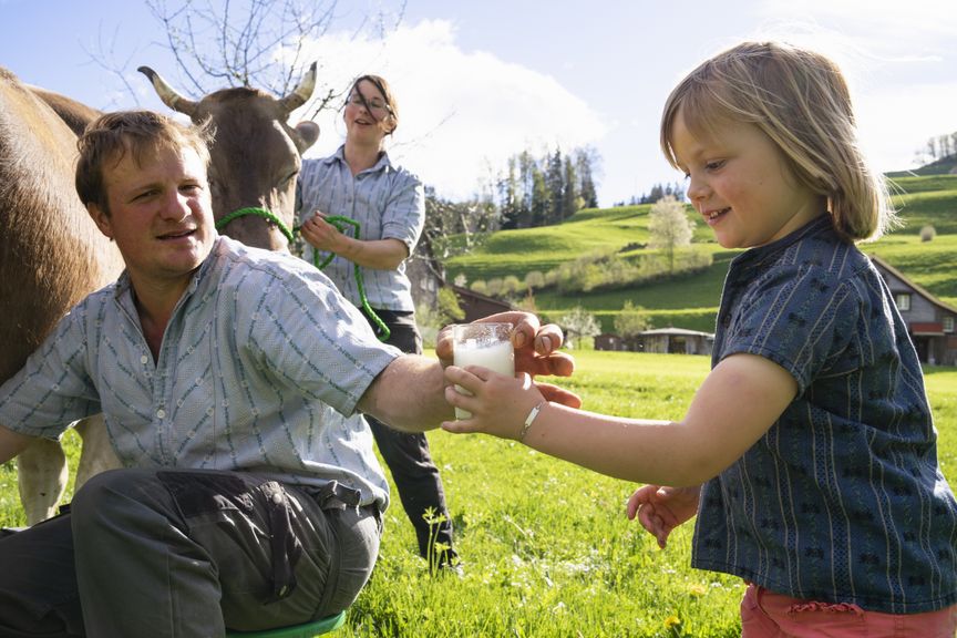 Kind nimmt ein Glas Milch direkt nach dem Melken 