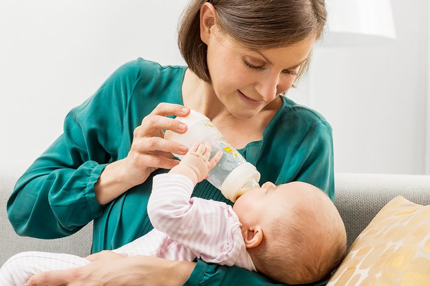 Mutter gibt ihrem Baby den Schoppen