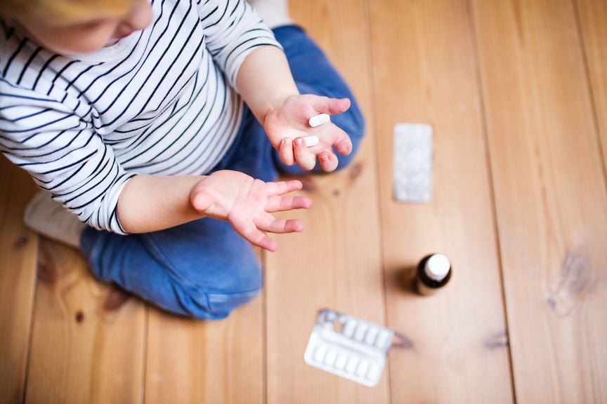 Kind hält Medikamente in der Hand