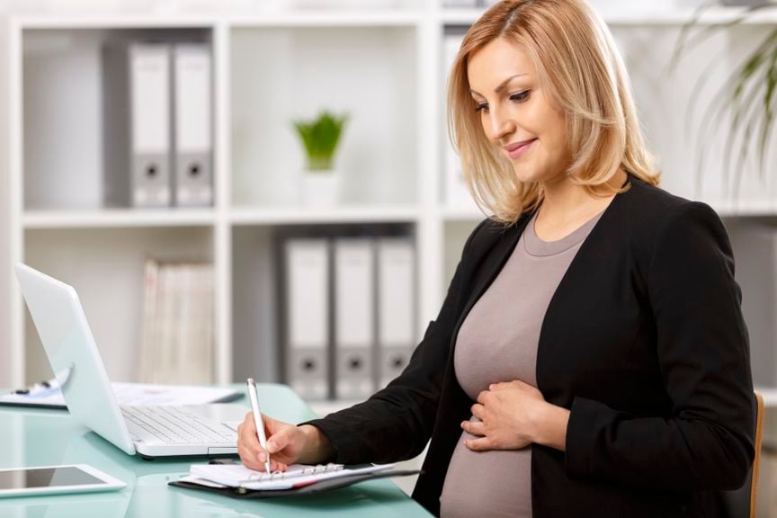 Schwangere Frau macht Agendaeintrag