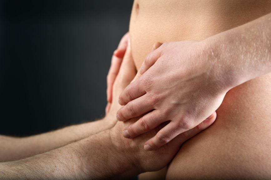 Partner berührt den Unterbauch der Frau
